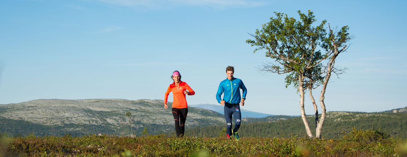 Två personer springer på fjället i Storhogna