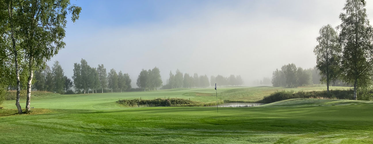 Hede golfbana under sommaren, dimmig och solig morgon