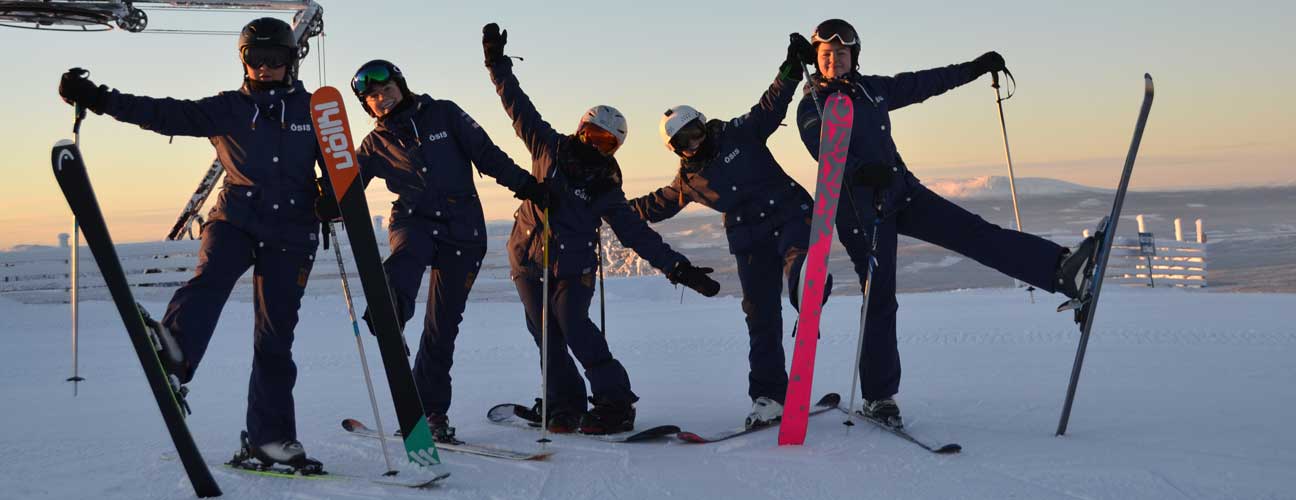 Glada studenter med slalomskidor framför sonfjället.