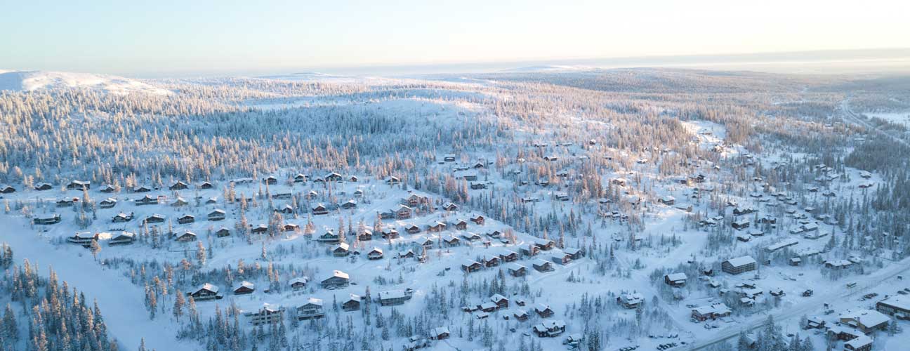 drönarvy av stugor i vinterlandskap i Vemdalsskalet.