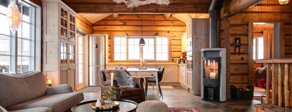 Interiörbild från en timmerstuga med kamin och modern inredning.