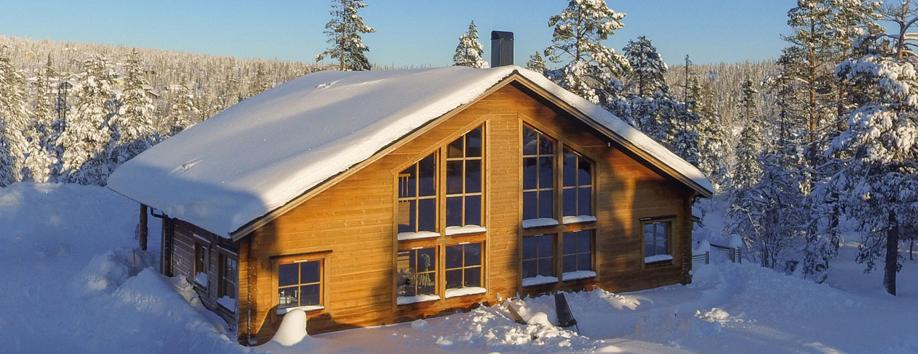 Storhogna Lodge, stor vinterlodge med stora fönster i vintrigt landskap