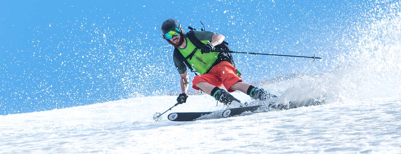 Skidåkare i shorts och t-shirt åker skidor på vårvintern