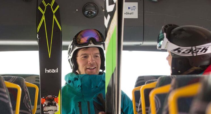 man med skidor kliver på skidbussen i Vemdalen