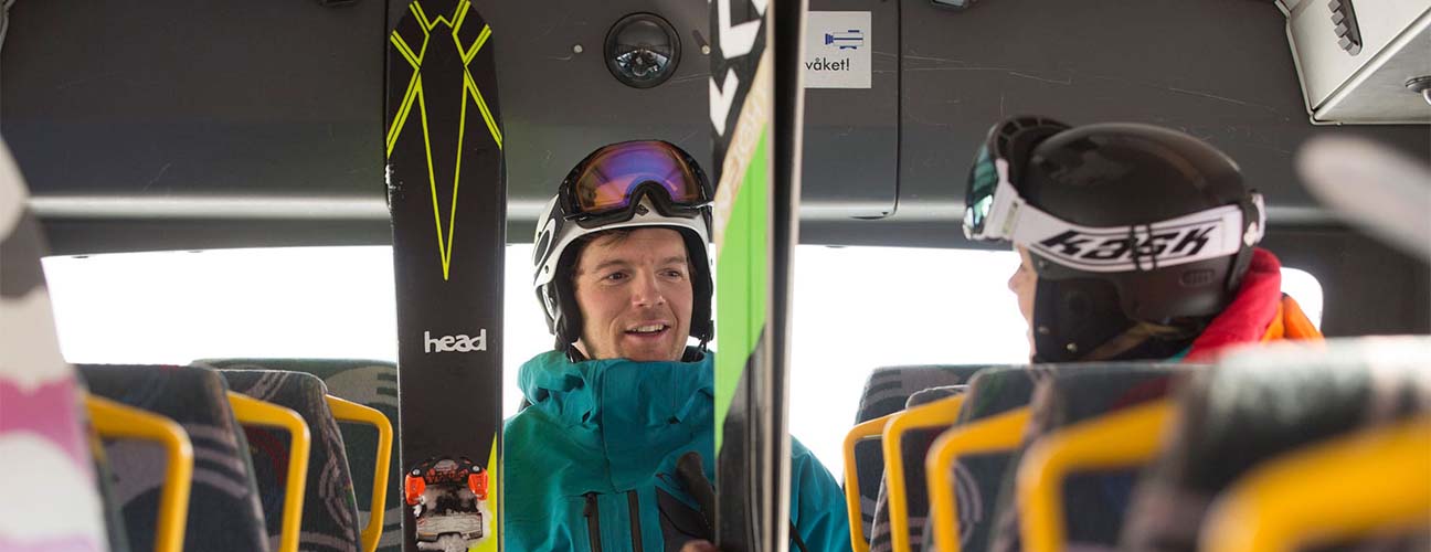 man med skidor kliver på skidbussen i Vemdalen